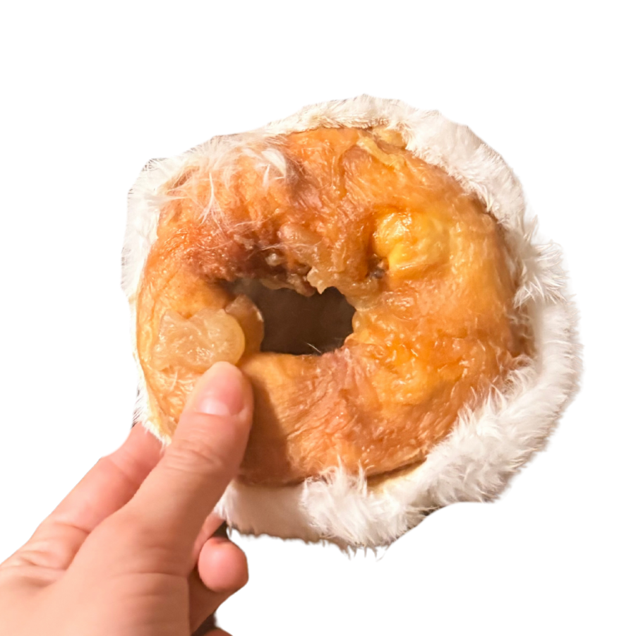Hand holding a treatosbox rabbit donut with white fur on a white background
