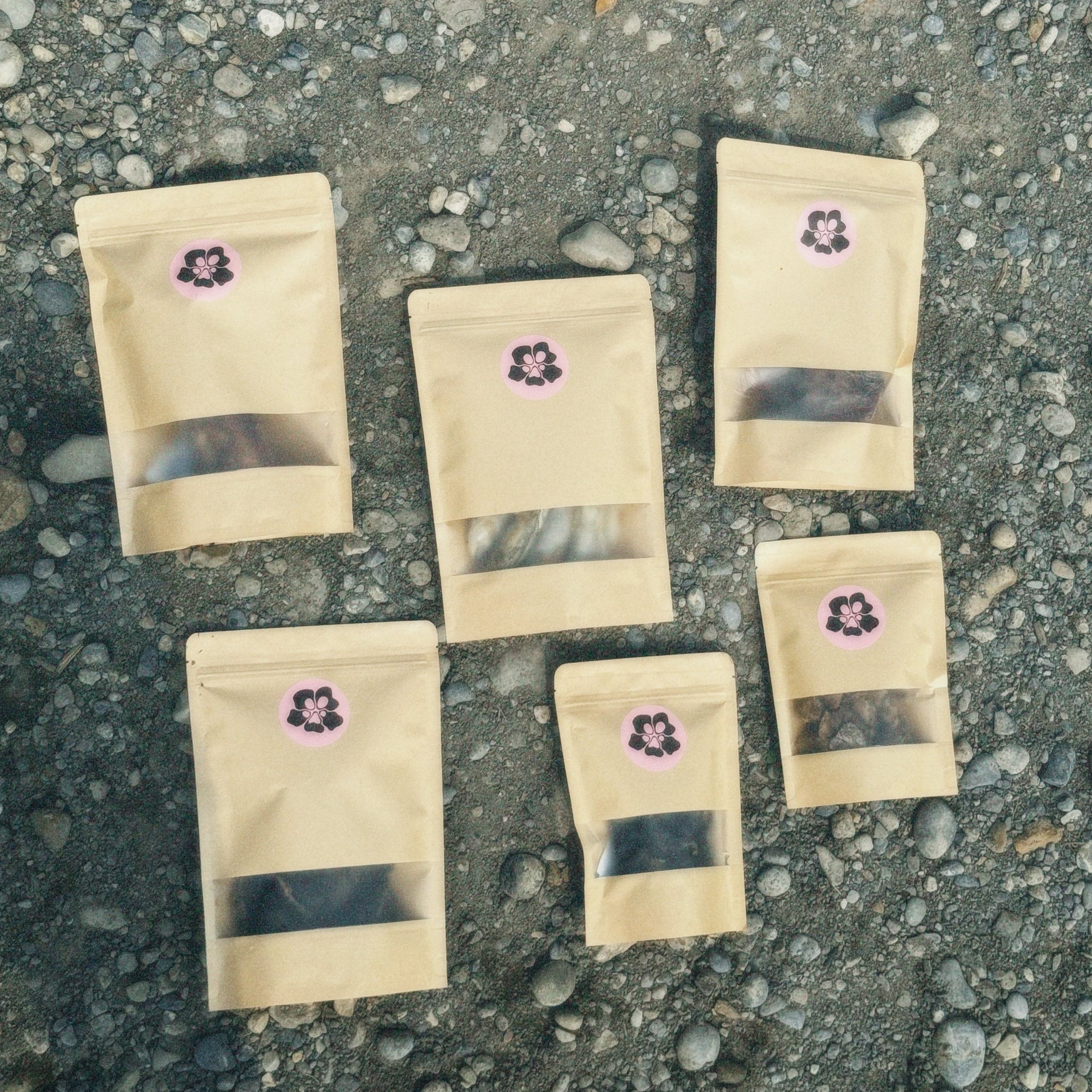 Six treatos box recyclable bags with purple labels on a concrete surface